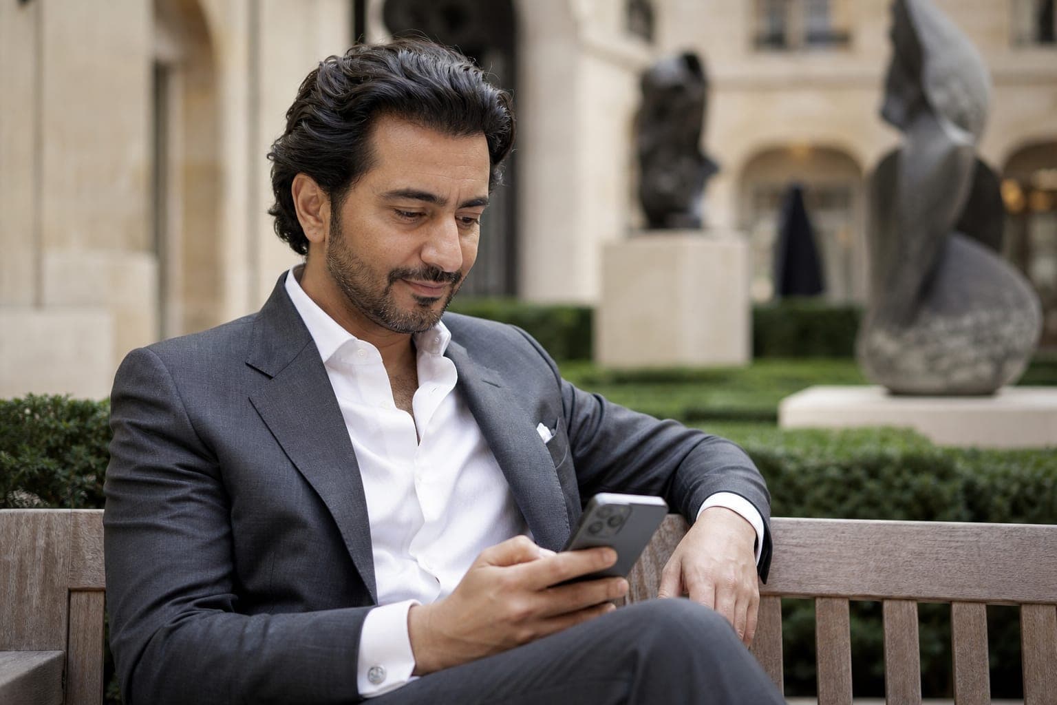 An Urologist scanning the day's papers on a phone in the courtyard of a luxury hotel